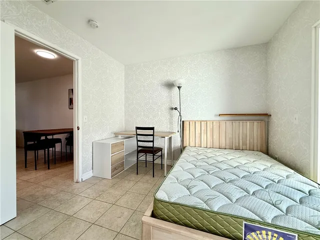 a bedroom with a bed and chair