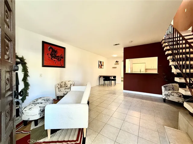 a living room with furniture a flat screen tv and a window