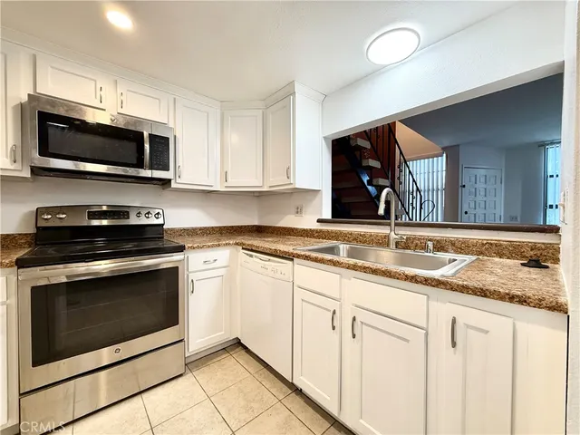 a kitchen with stainless steel appliances granite countertop a stove microwave and sink