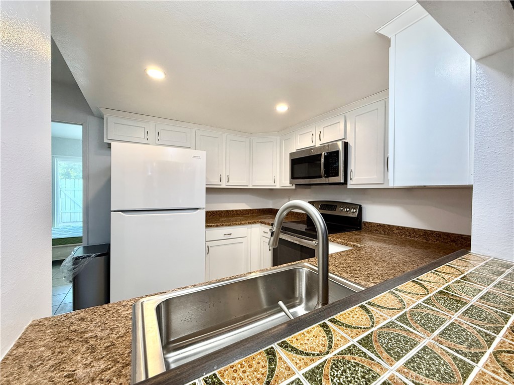 1415 Everton Place Riverside, CA 92507 - Photo 9 of 24 a kitchen with a refrigerator a microwave a sink and a stove