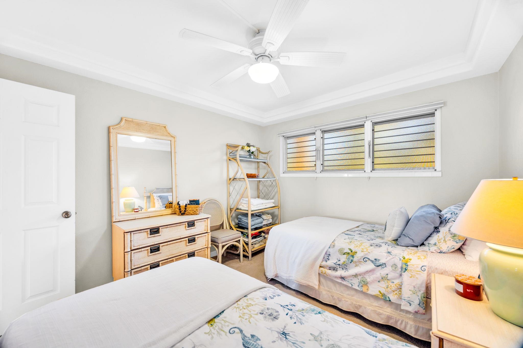 2430 South Kihei Road, Unit 515 Kihei, HI 96753 - Photo 31 of 50 a bedroom with two beds and a chandelier