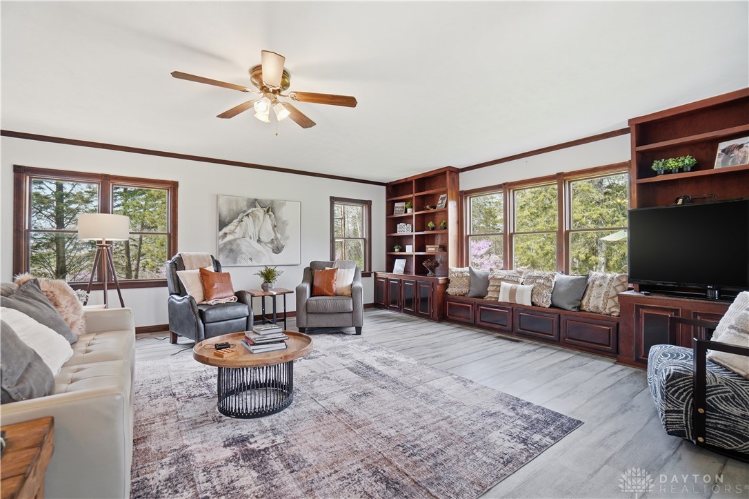 7553 Coffin Station Road Springfield, OH 45502 - Photo 21 of 95 This bright living room features built-in shelving, expansive windows, and durable flooring.