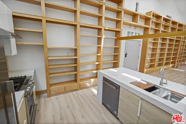 a kitchen with a sink a stove and wooden floor