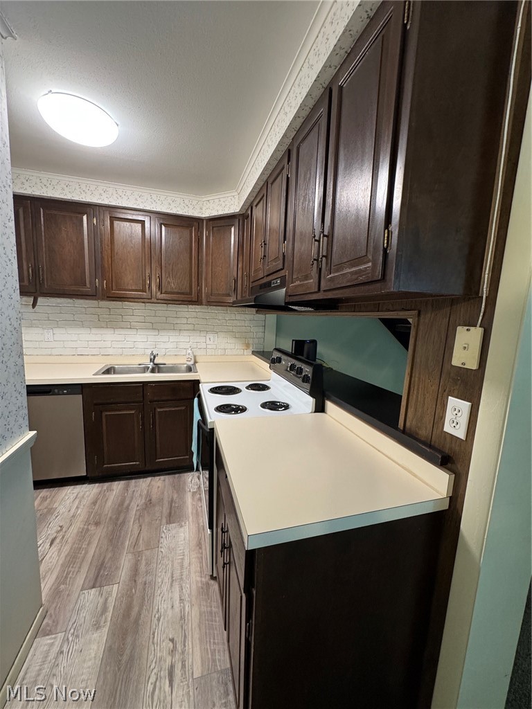 7294 Fox Mill Road, Unit 19D Mentor, OH 44060 - Photo 15 of 27 Kitchen featuring wood-finish cabinetry, light countertops, wood-finish flooring, a newer stainless steel dishwasher and electric range.