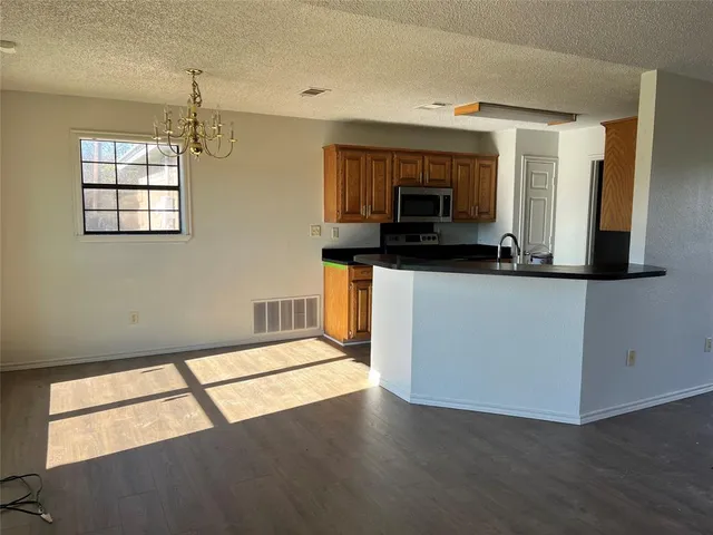 a kitchen with stainless steel appliances kitchen island granite countertop a stove a sink and a microwave