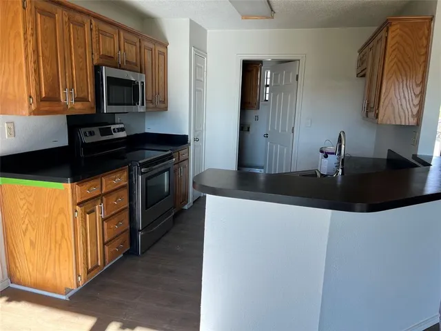 a kitchen with stainless steel appliances granite countertop a sink stove and microwave