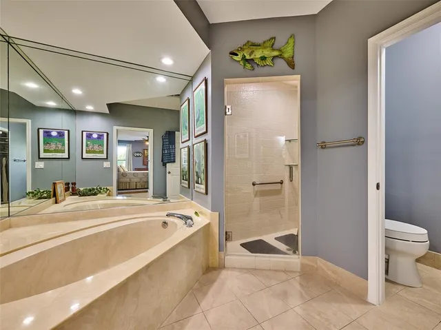 a spacious bathroom with a tub shower and toilet