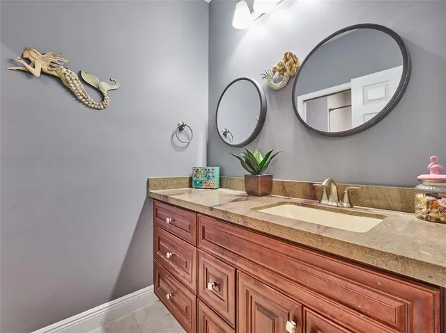 a bathroom with a granite countertop double vanity and a mirror