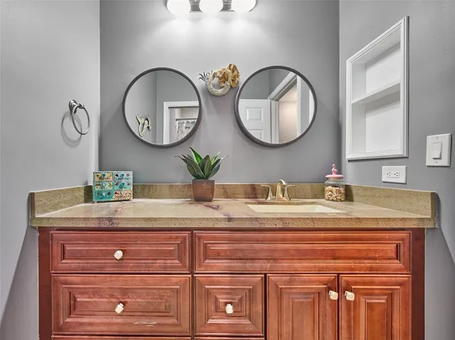 a bathroom with a granite countertop sink and a mirror