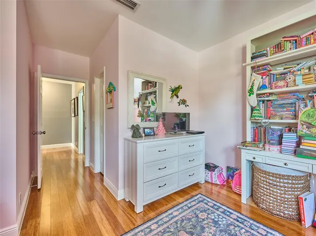 a hall with a baby crib and a dresser