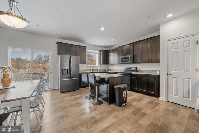 a kitchen with refrigerator a stove and chairs