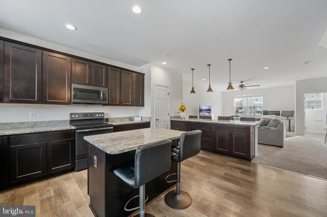 a kitchen with stainless steel appliances granite countertop a stove and a wooden floors