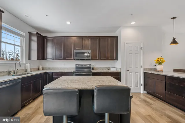 a kitchen with a dining table chairs sink and stove