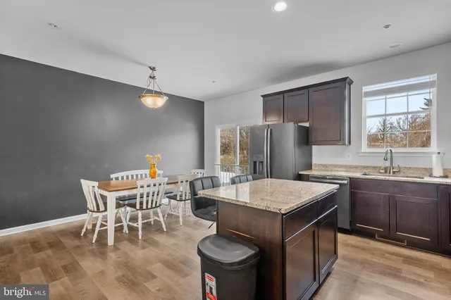 a living room with furniture kitchen view and a chandelier