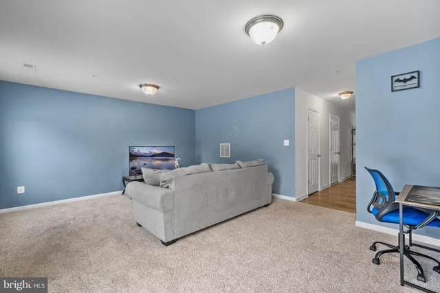 a living room with furniture and a air conditioner vent