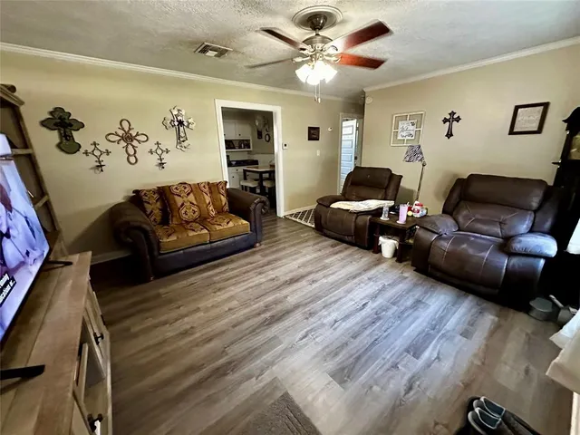 a living room with furniture and a wooden floor