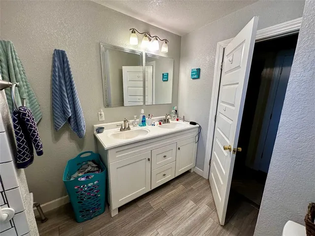 a bathroom with a sink a mirror a vanity and a shower