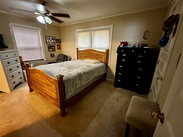 a bedroom with a bed and a flat tv screen on dresser