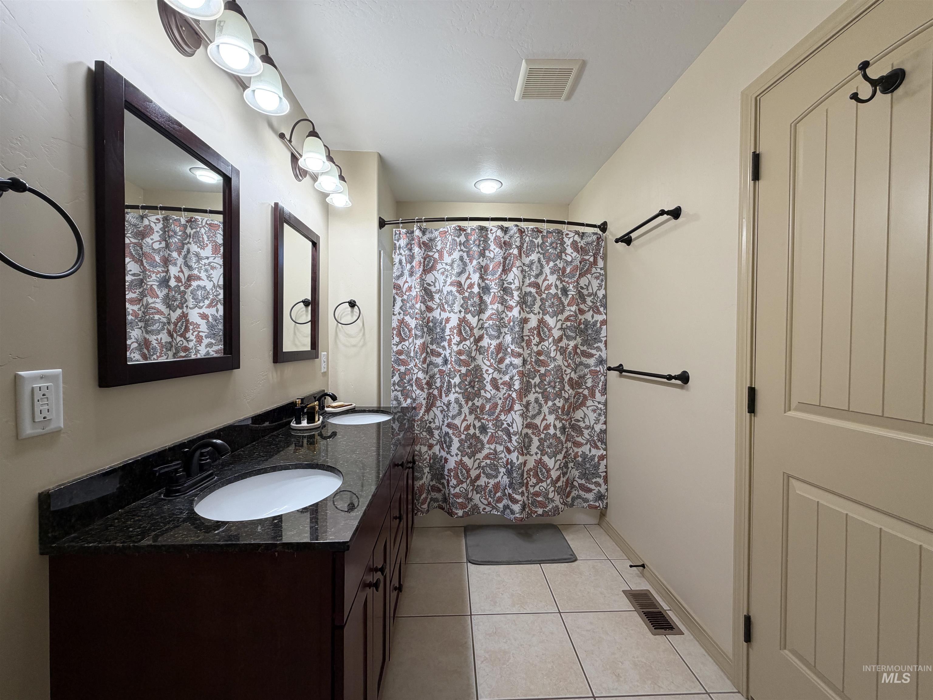 2000 M Street Heyburn, ID 83336 - Photo 7 of 15 Dual vanity with dark wood-finish cabinetry and dark granite-look countertops