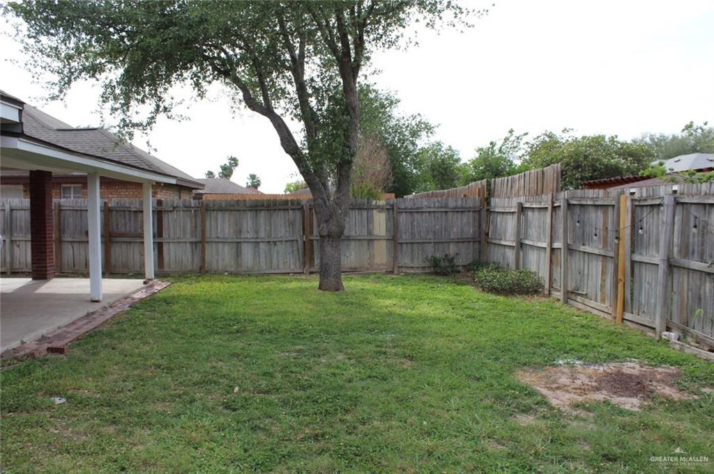 3824 Umar Avenue McAllen, TX 78504 - Photo 8 of 15 a view of a backyard with a large tree and wooden fence