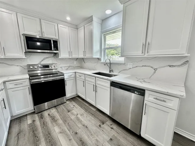 a kitchen with a sink stove and microwave