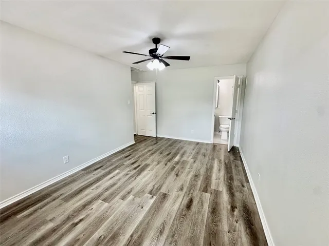a view of a room with a wooden floor and a ceiling fan