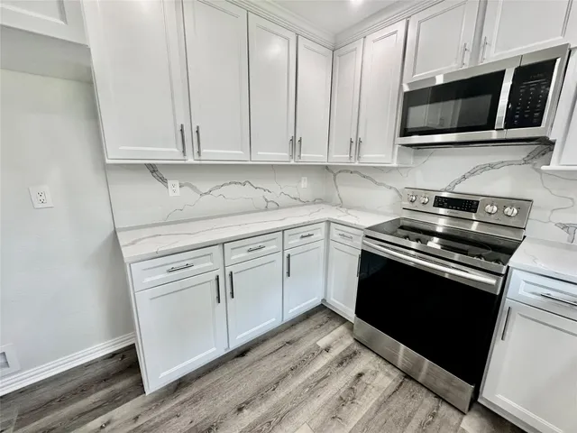 a kitchen with stainless steel appliances granite countertop white cabinets a sink and dishwasher