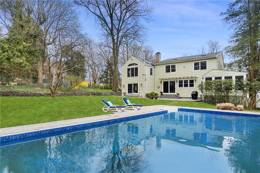 a view of an house with swimming pool and yard