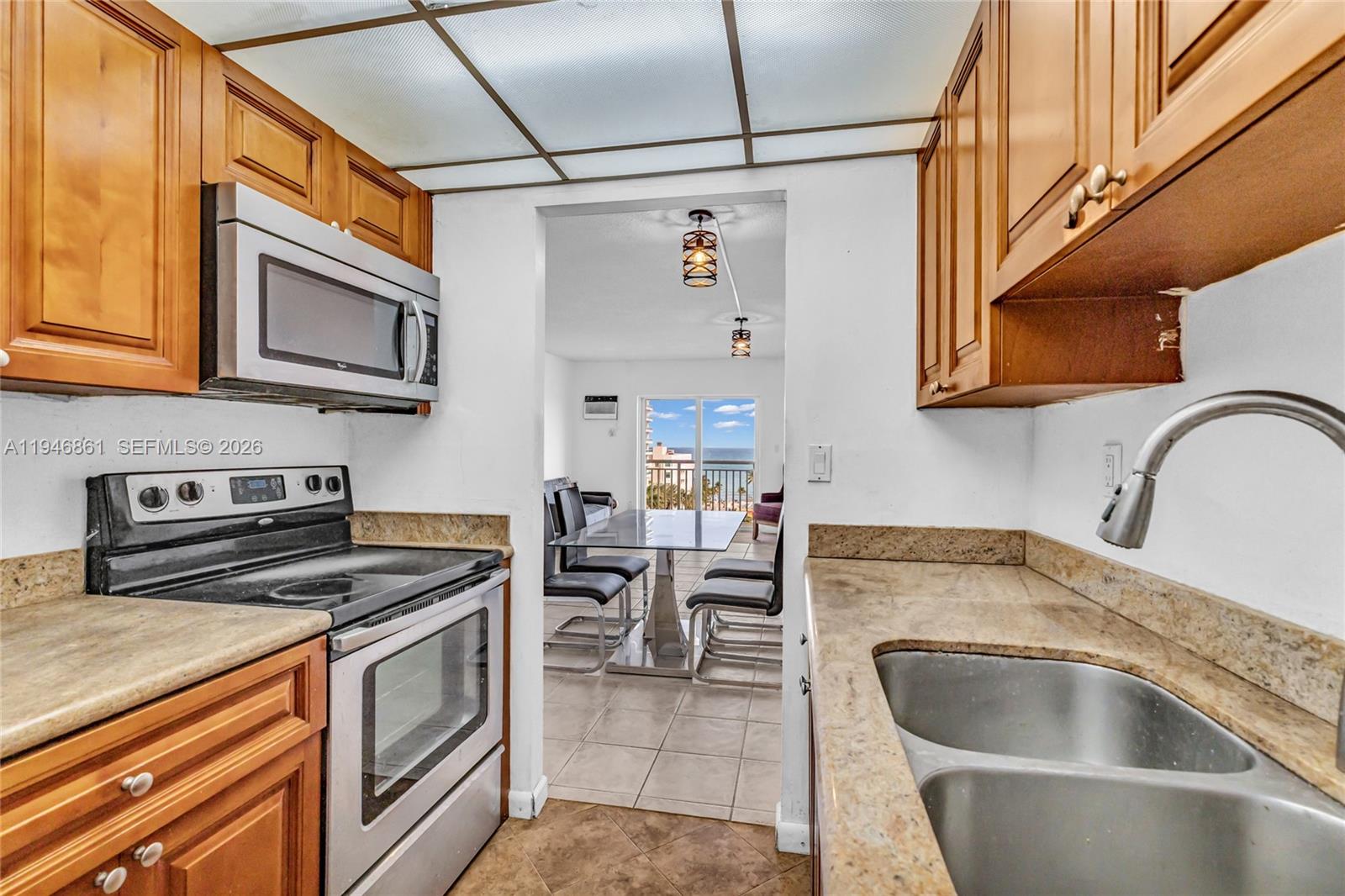 200 South Birch Road, Unit 1015 Fort Lauderdale, FL 33316 - Photo 9 of 36 a kitchen with stainless steel appliances granite countertop a sink and a stove