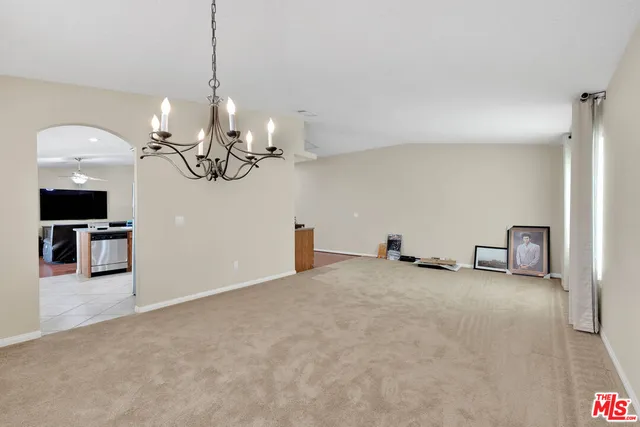 an empty room with windows and a ceiling fan