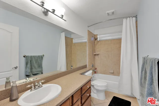 a bathroom with a sink a toilet a mirror and bathtub