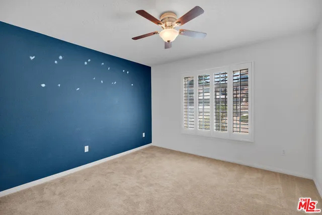 an empty room with closet and a chandelier fan