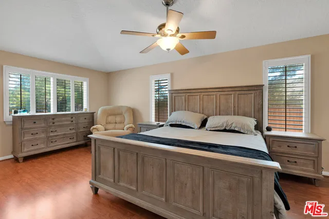 a bedroom with a bed tv and a window