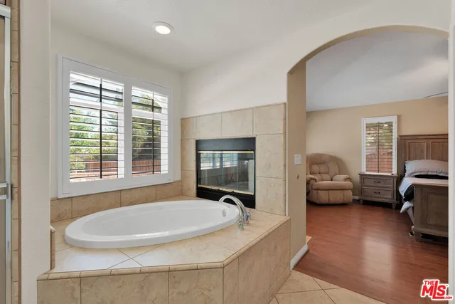 a bathroom with a tub sink and mirror