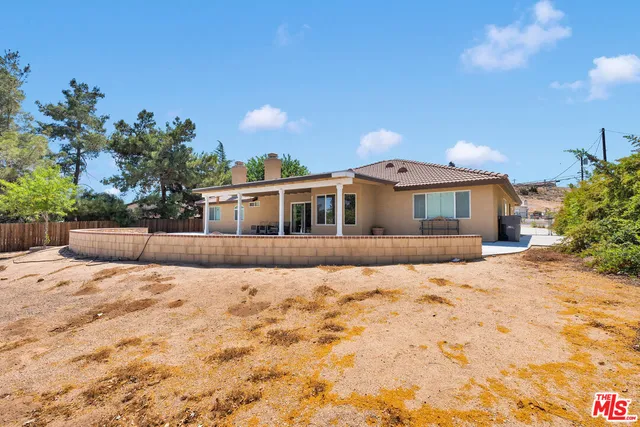 a view of a house with backyard and tree