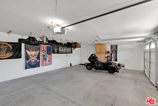 an aerial view of a house with swimming pool and large trees