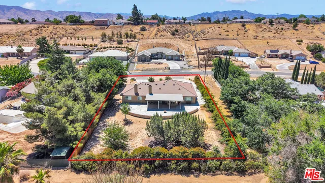 an aerial view of a house with a yard and lake view