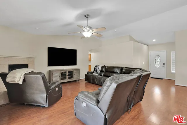 a large bedroom with a large bed a flat tv screen and a fireplace