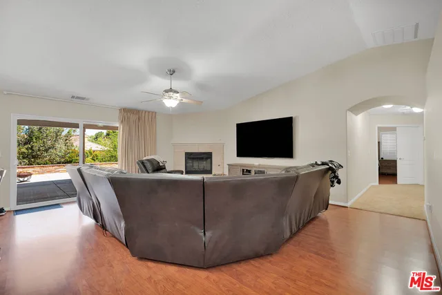 a kitchen with stainless steel appliances granite countertop a stove top oven a sink dishwasher a refrigerator and a dining table with wooden floor