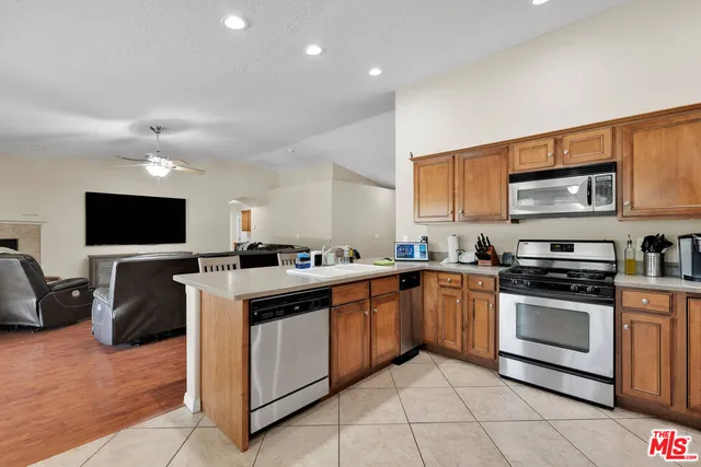 a kitchen with stainless steel appliances granite countertop a refrigerator sink and stove