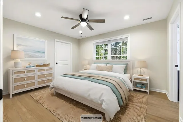 an empty room with wooden floor chandelier ceiling fan and windows