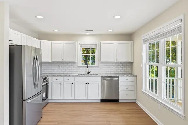 a kitchen with a sink windows and cabinets