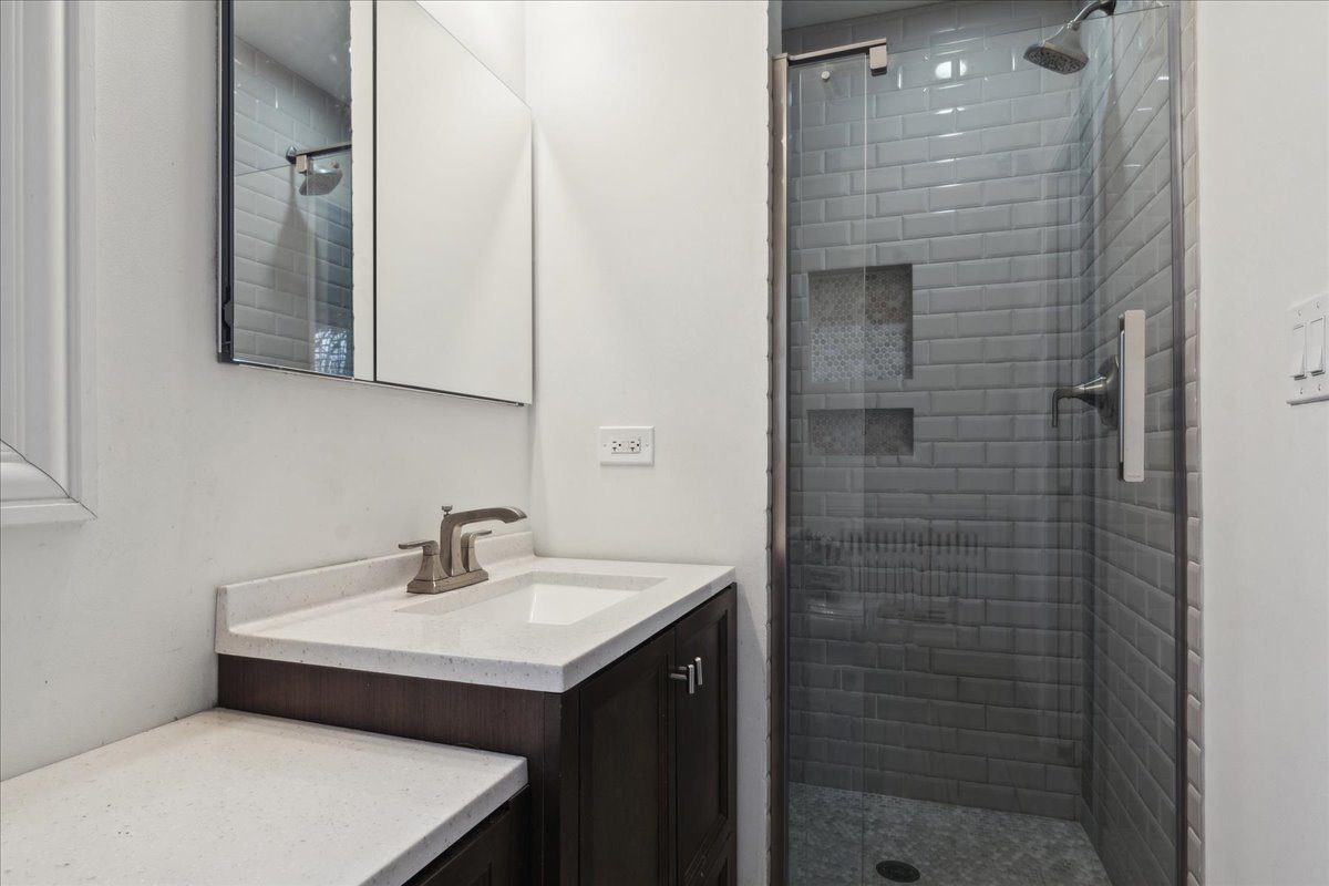 918 Oxford Road Deerfield, IL 60015 - Photo 15 of 26 a bathroom with a sink a mirror and shower