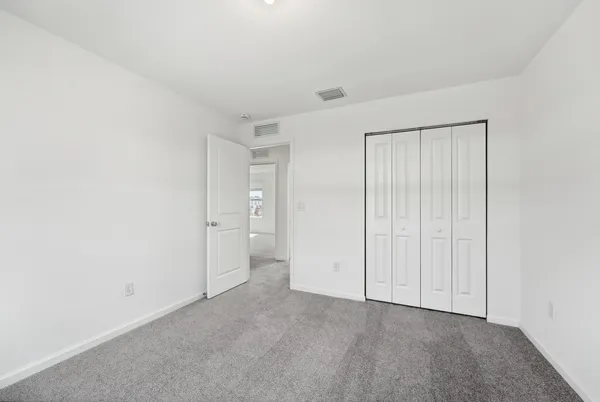 a view of an empty room and closet area