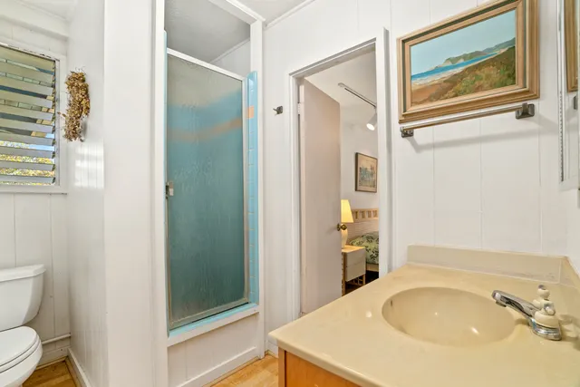 a bathroom with a sink a toilet and shower