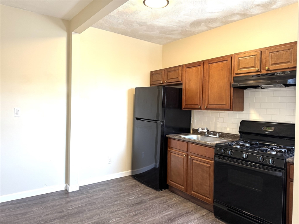 a kitchen with a refrigerator stove and cabinets