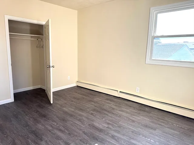an empty room with wooden floor and a window