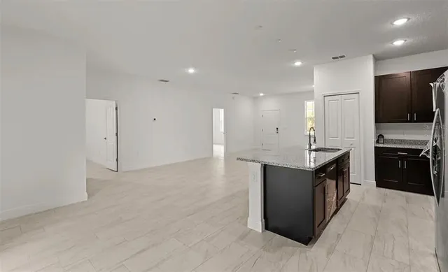 a kitchen with granite countertop a sink stove and cabinets