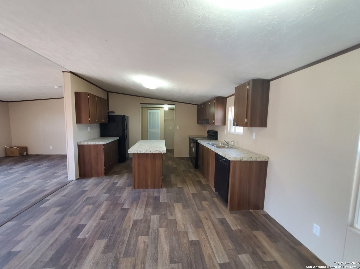 61 Post Oak Road, Unit A La Vernia, TX 78121 - Photo 4 of 11 a large kitchen with stainless steel appliances a large counter top a stove and a wooden floors