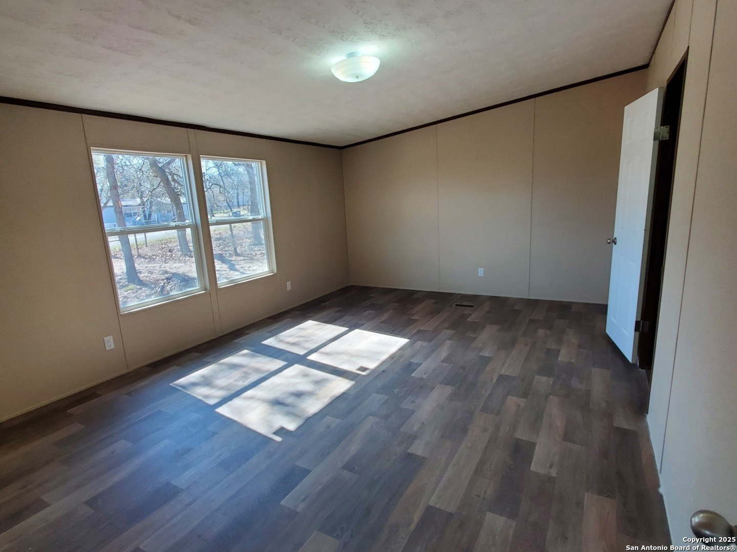 61 Post Oak Road, Unit A La Vernia, TX 78121 - Photo 5 of 11 an empty room with wooden floor and windows